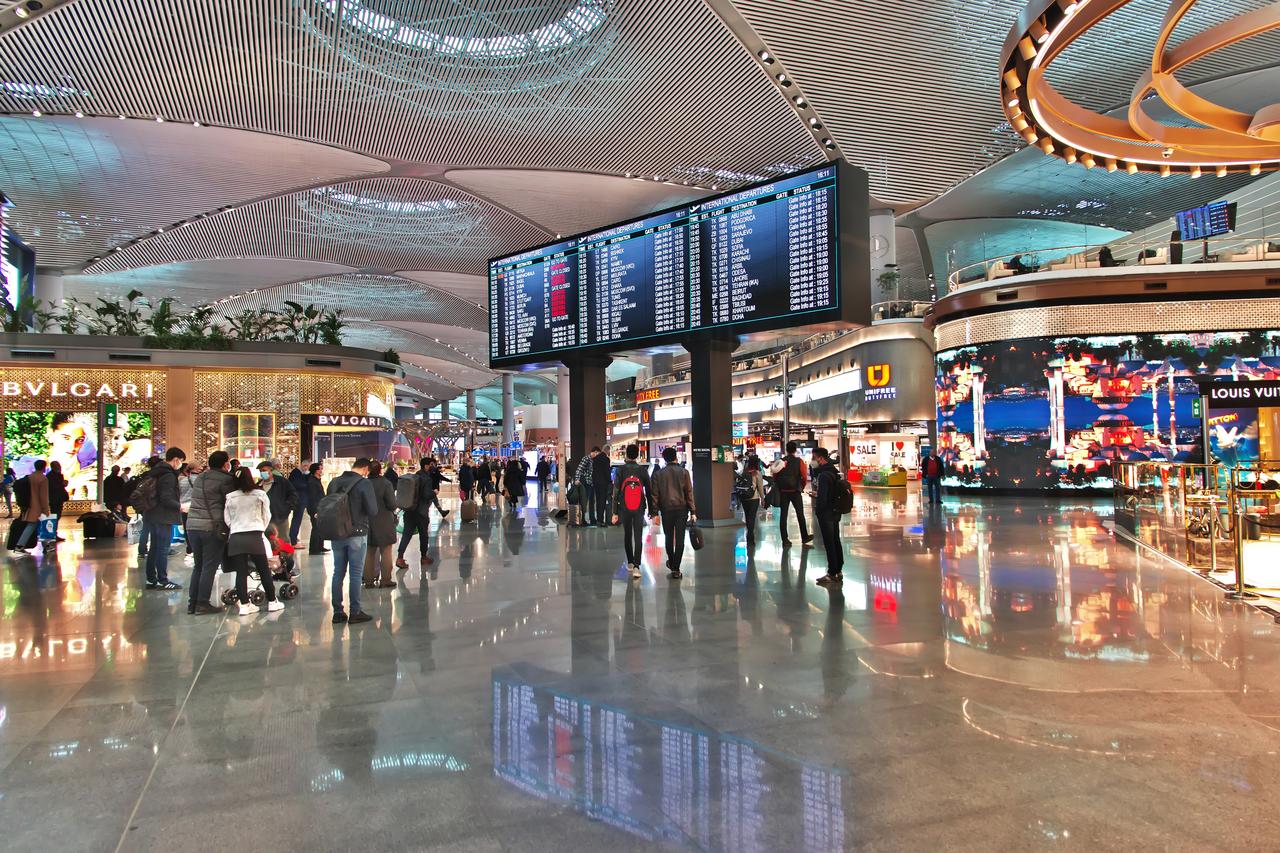 Travelers browse luxury shops and check flight information in the international departures hall at Istanbul Airport in Türkiye on March 20, 2021. (Adobe Stock Photo)