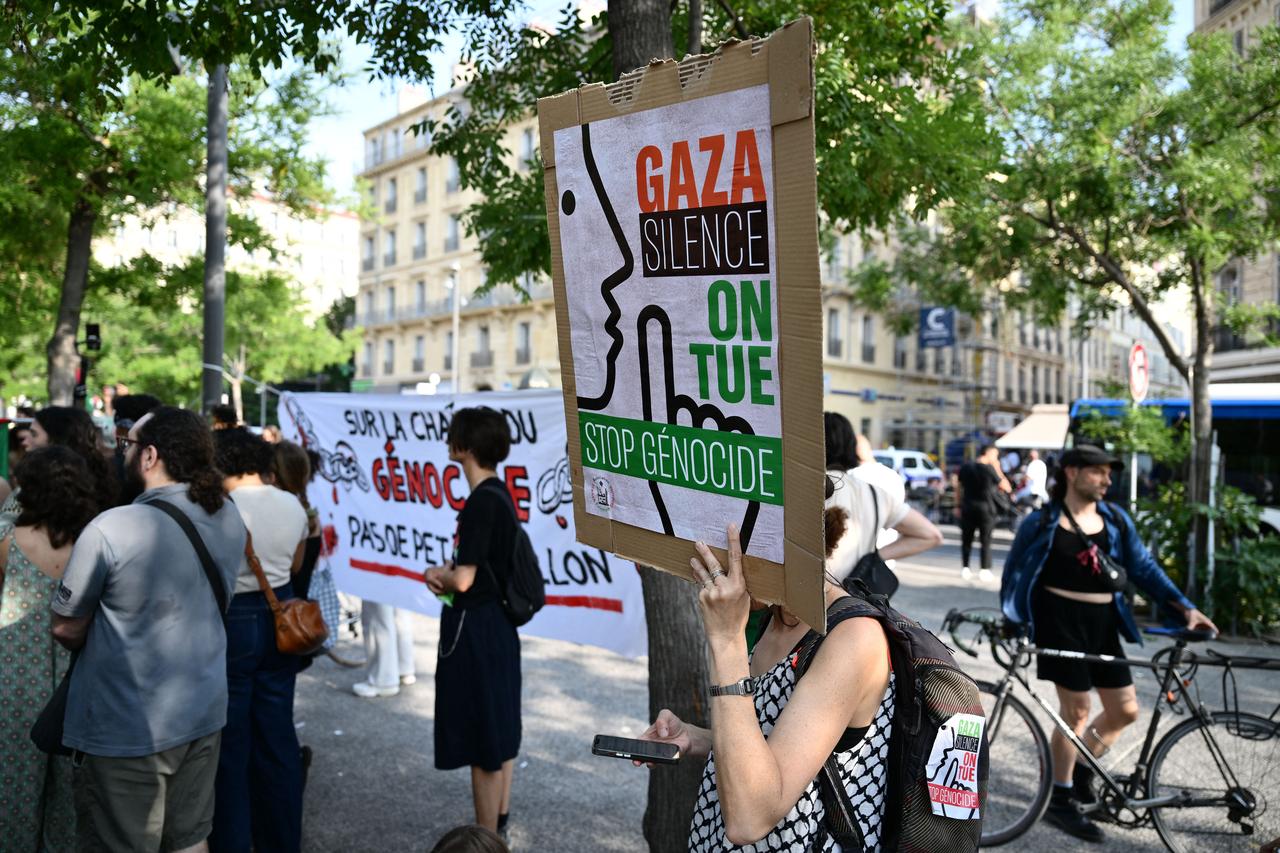 A demonstrator holds a placard reading  Gaza silence, we are killing, stop genocide  during a gathering against the shipment of military equipment parts to Israel, in Marseille on June 5, 2025. (AFP Photo)