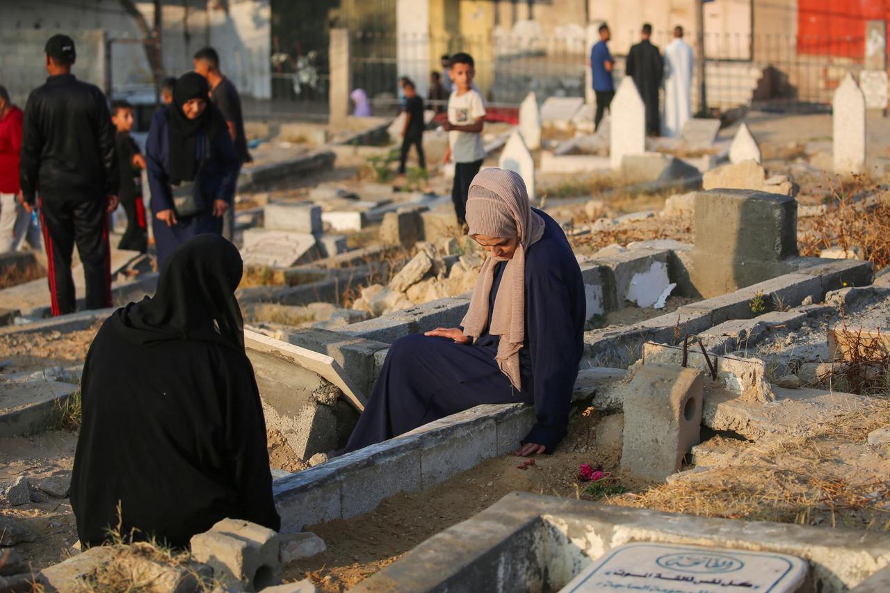 Palestinians visit the graves of their loved ones on the first day of the Muslim Eid al-Adha festival in Nuseirat, in the central Gaza Strip, on June 6, 2025, amid the ongoing war between Israel and Hamas. (Photo by Eyad BABA / AFP)