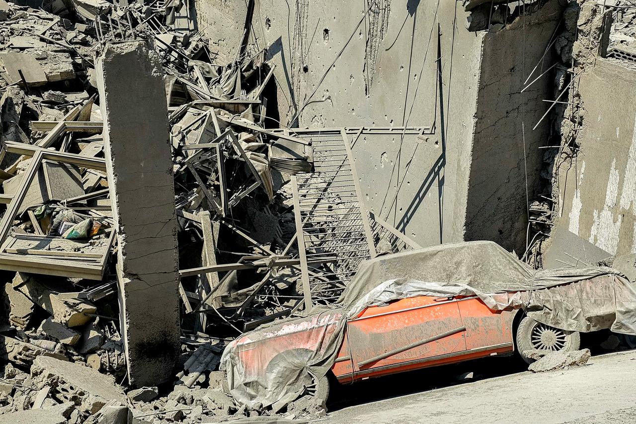 A damaged vehicle is pictured fallen into the crater of a collapsed building at the site of an overnight Israeli airstrike in the Kafaat neighbourhood of Beirut’s southern suburbs on June 6, 2025. (AFP Photo)