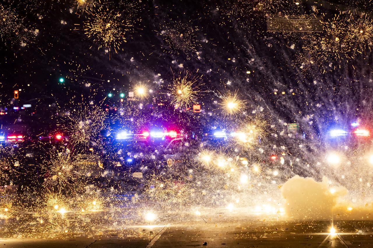 Fireworks explode in front of law enforcement as they face off with demonstrators during a protest following federal immigration operations, in the Compton neighborhood of Los Angeles, California early on June 8, 2025. US President Donald Trump deployed 2,000 troops on June 7 to handle escalating protests against immigration enforcement raids in the Los Angeles area, a move the states governor termed  purposefully inflammatory.  Federal agents clashed with angry crowds in a Los Angeles suburb as protests stretched into a second night Saturday, shooting flash-bang grenades and shutting part of a freeway amid raids on undocumented migrants, reports said. (Photo by ETIENNE LAURENT / AFP)