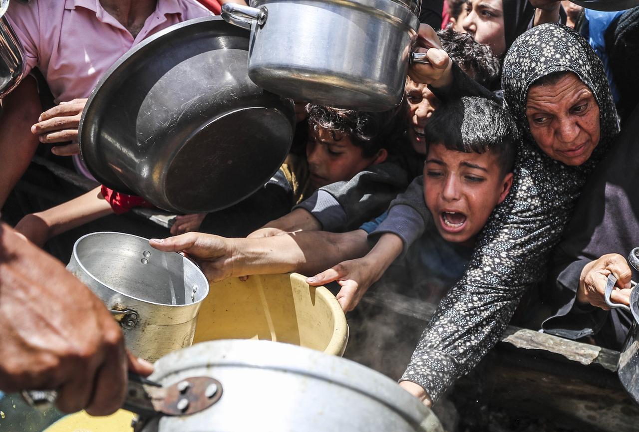 Palestinians, struggling with hunger due to Israeli embargo, wait in line to receive hot meals distributed by the charity organizations as Israeli attacks continue, in Jabalia Refugee Camp in Gaza City, Gaza on May 26, 2025. (AA Photo)