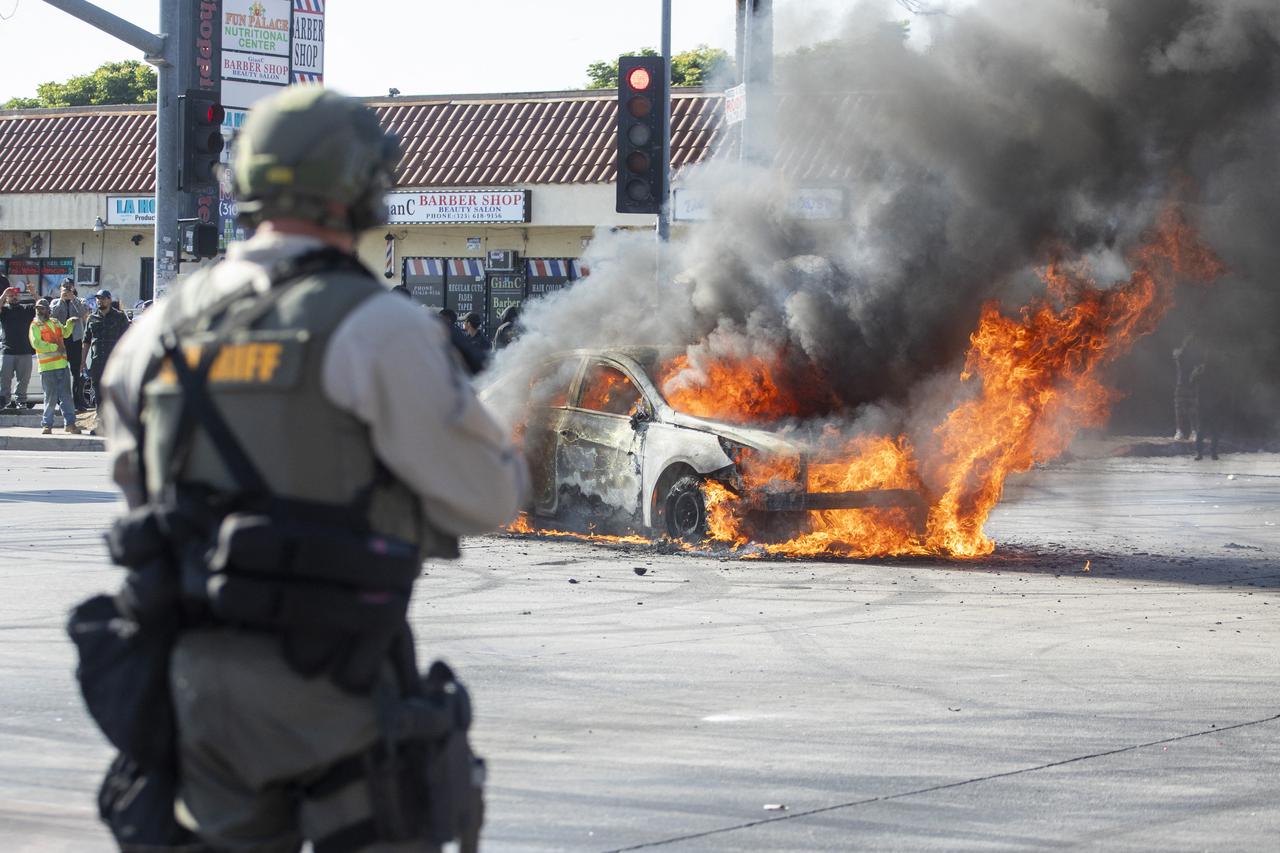 A car burns as law enforcement clashes with demonstrators during a protest following federal immigration operations, in the Compton neighborhood of Los Angeles, California on June 7, 2025. (AFP Photo)