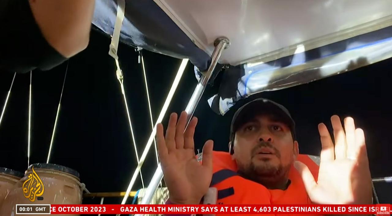 An activist is seen raising his hands after Israeli soldiers boarded the Madleen aid ship. (X/@AryJeay)
