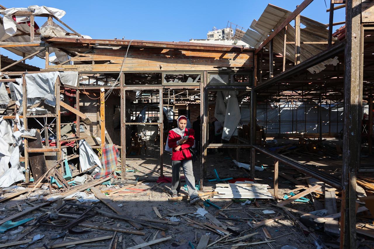 A Palestinian woman walks on debris at Al-Baqa cafeteria which was devastated in an Israeli strike on the Gaza City seafront on June 30, 2025. (AFP Photo)