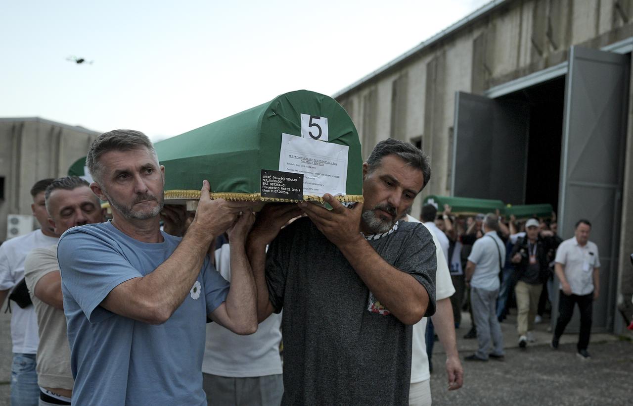 Yas tutanları, 10 Temmuz 2025'te Potocari'deki eski pil fabrikasında yedi Srebrenica soykırım kurbanının yeşil yıpranmış tabutlarının etrafında toplanıyor. (AA Photo)