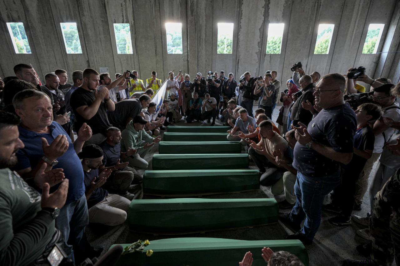 Mourners gather around the green-shrouded coffins of seven Srebrenica genocide victims at the former battery factory in Potocari on July 10, 2025. (AA Photo)
