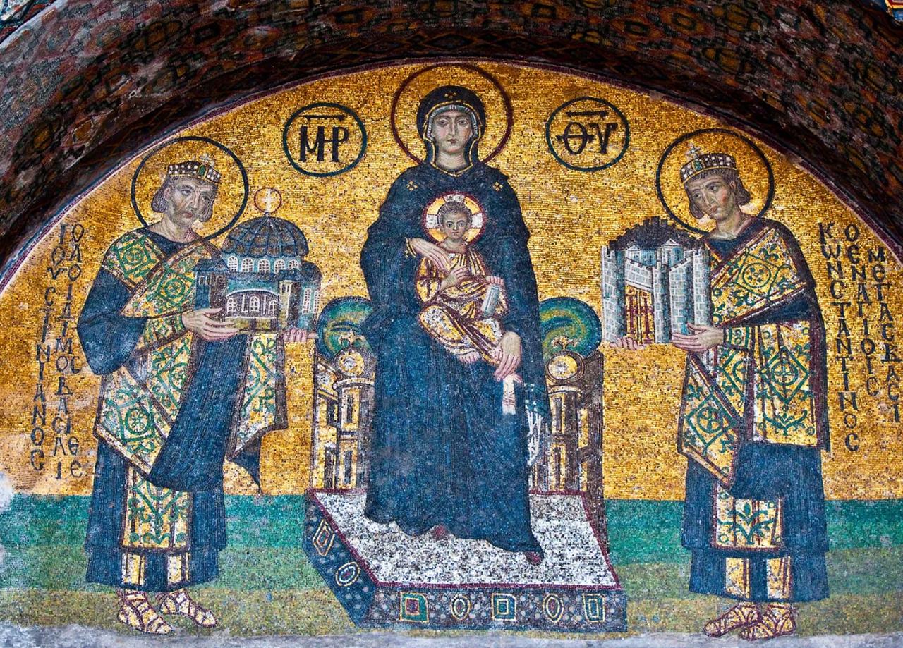 The Virgin Mary holding the Christ Child (C), Justinian (L) holding a model of the Hagia Sophia, and Constantine (R) holding a model of the city of Constantinople; mosaic from the Hagia Sophia, 9th century. (Photo via Wikimedia)