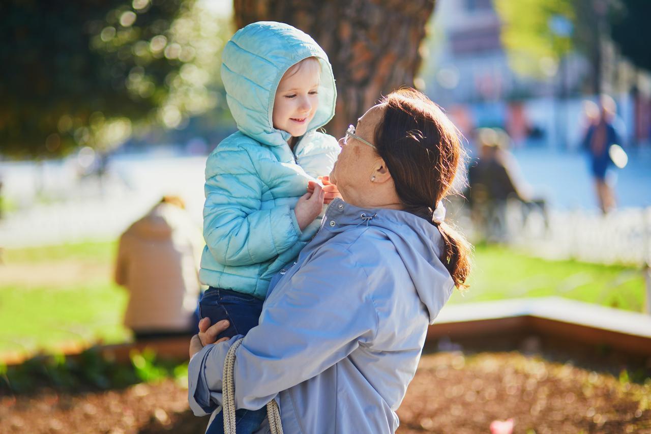 A woman holds a child during a walk in a public park in Türkiye. (Adobe Stock Photo)