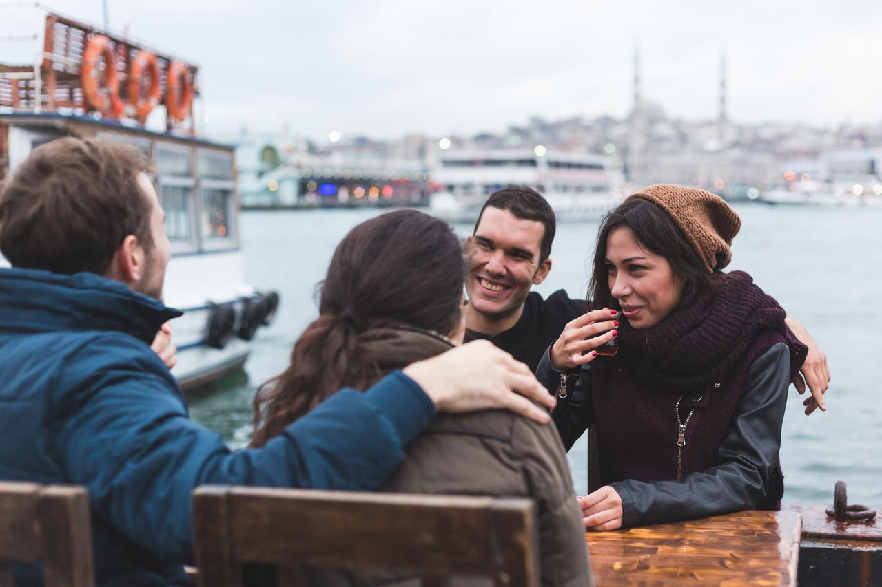 A group of friends enjoys a conversation near Bosphorus waterfront, in Istanbul, Türkiye. (Adobe Stock Photo)