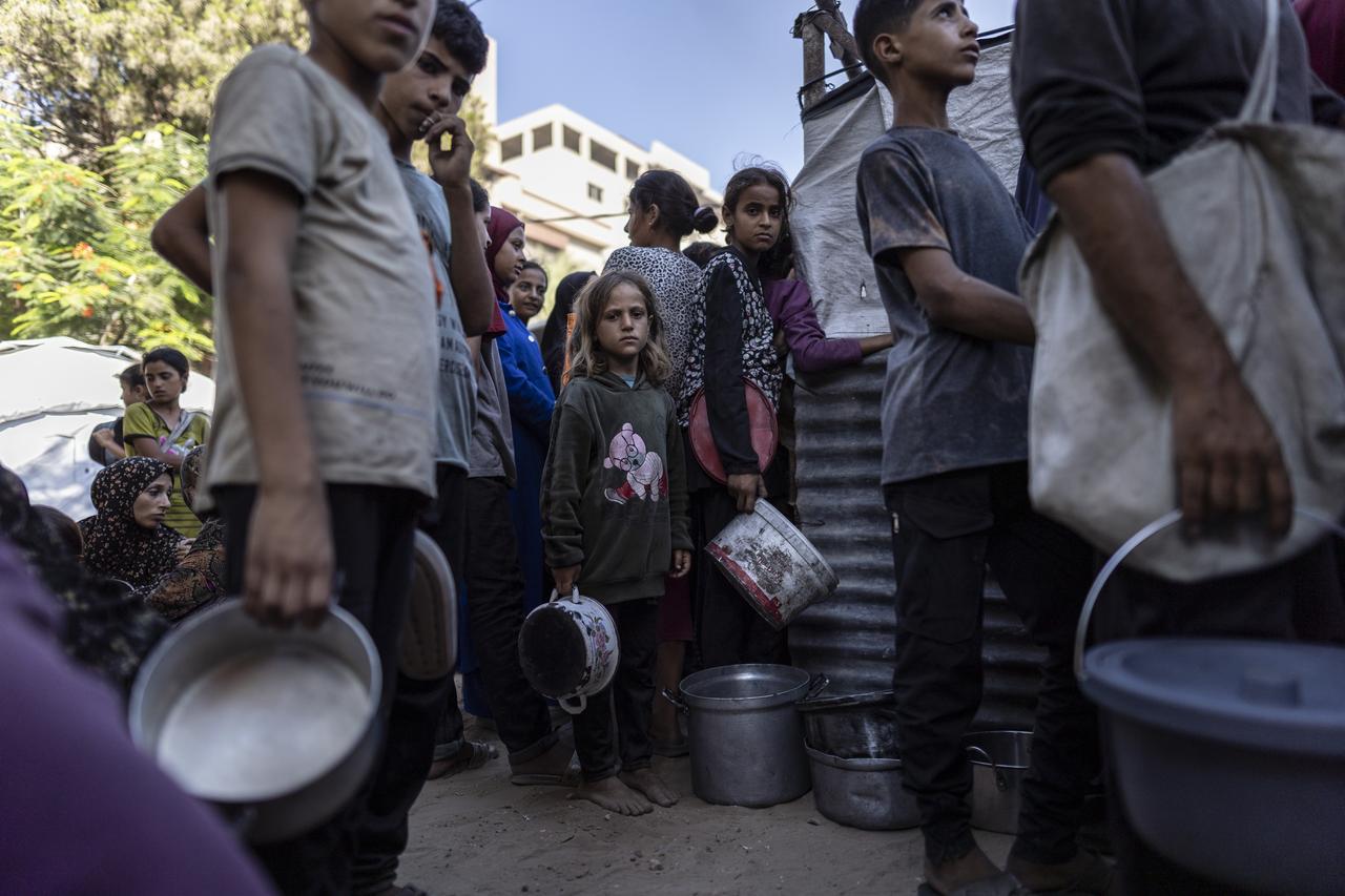 Palestinians, including children gather in large numbers to receive meals distributed by a charity organization in the Al-Rimal neighborhood of Gaza City on Gaza on July 11, 2025. (AA Photo)