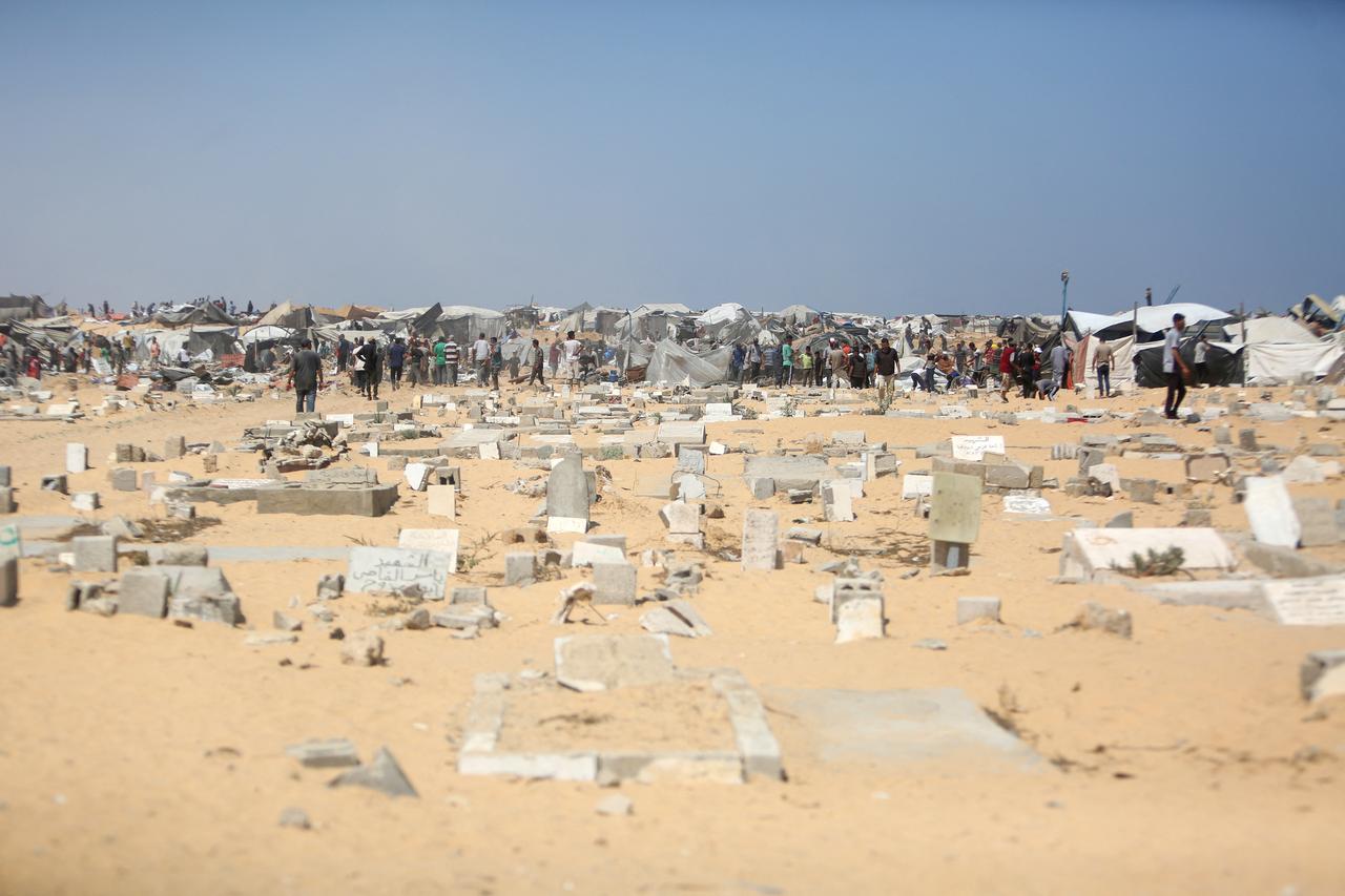 Palestinians inspect the destruction at a makeshift displacement camp and cemetery following a reported incursion a day earlier by Israeli tanks in the area in Khan Yunis in the southern Gaza strip, July 11, 2025. (AFP Photo)