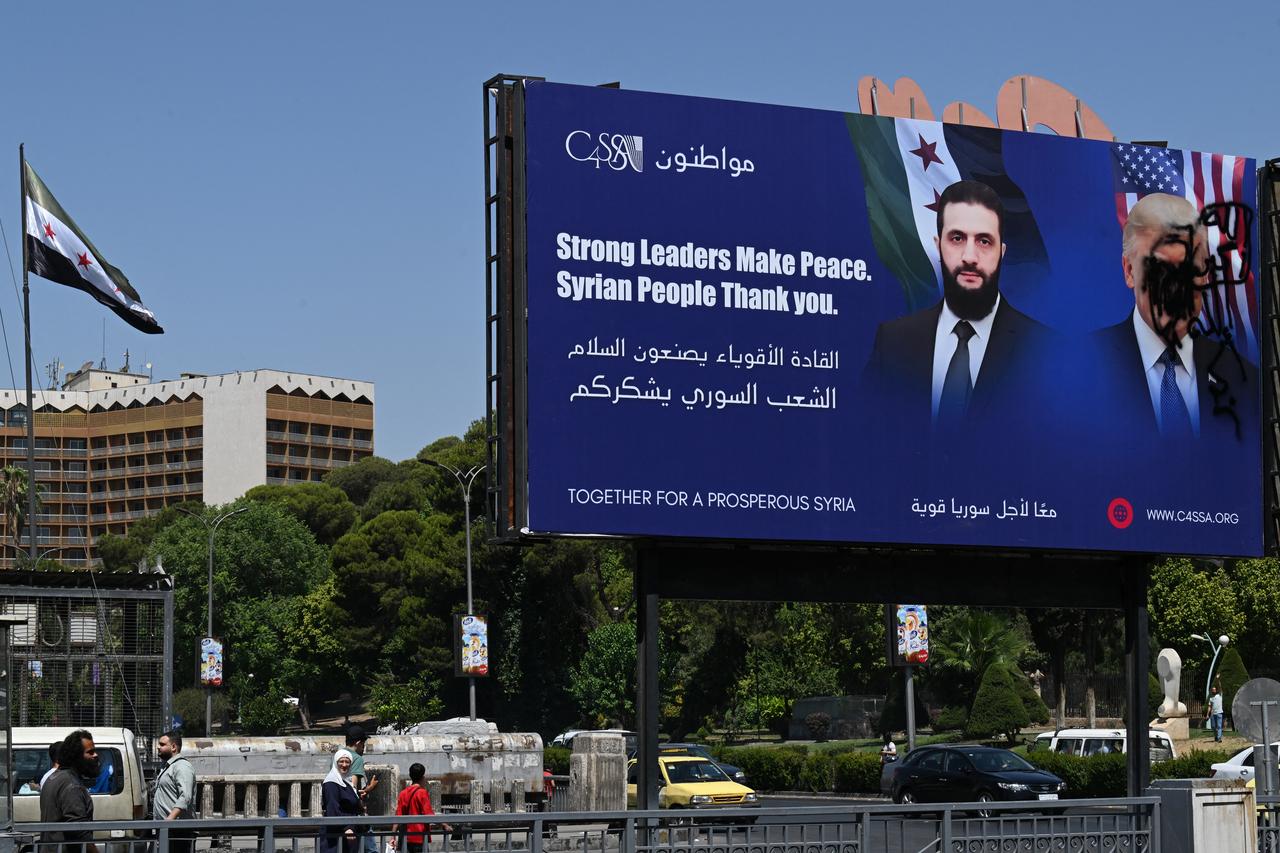 A picture shows a promotional poster bearing the portrait of Syria'sPresident Ahmad al-Sharaa next to a defaced portrait of US President Donald Trump in the capital Damascus on July 9, 2025. (AFP Photo)