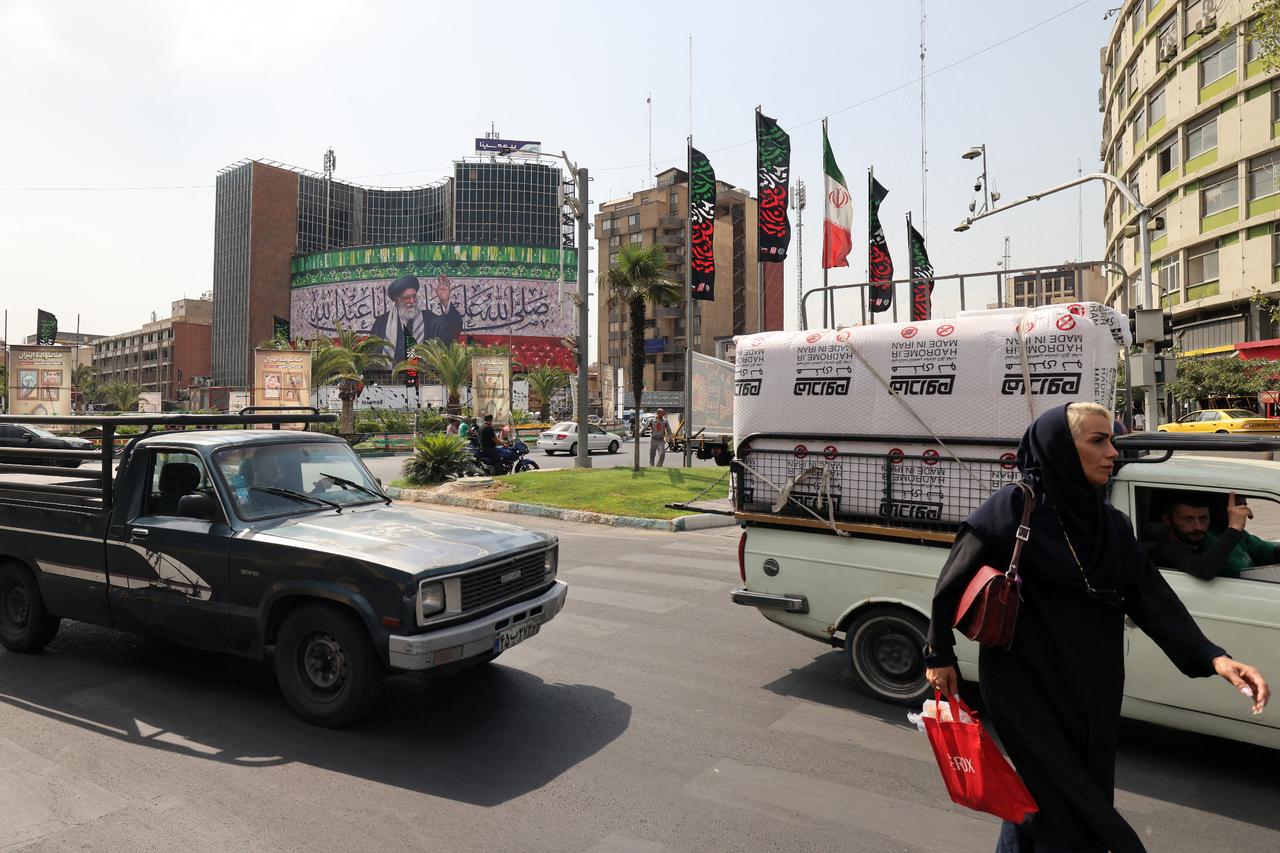 Motorists drive their vehicles past a billboard depicting Irans Supreme Leader Ayatollah Ali Khamenei displayed in Tehran on July 13, 2025. (AFP Photo)
