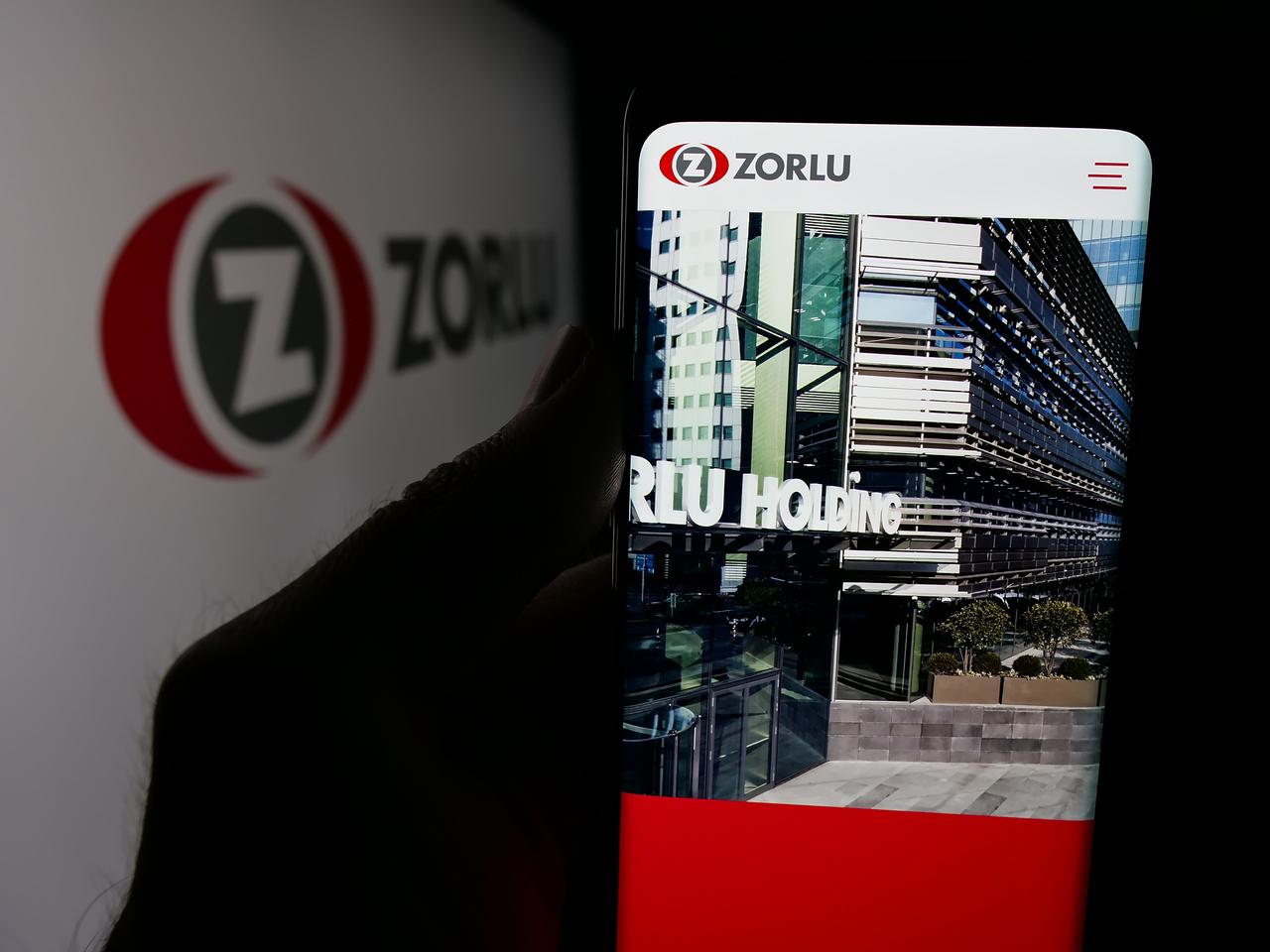Photo illustration shows a person holding a smartphone displaying the website of Türkiye’s Zorlu Holding in Stuttgart, Germany, on July 5, 2025. (Adobe Stock Photo)
