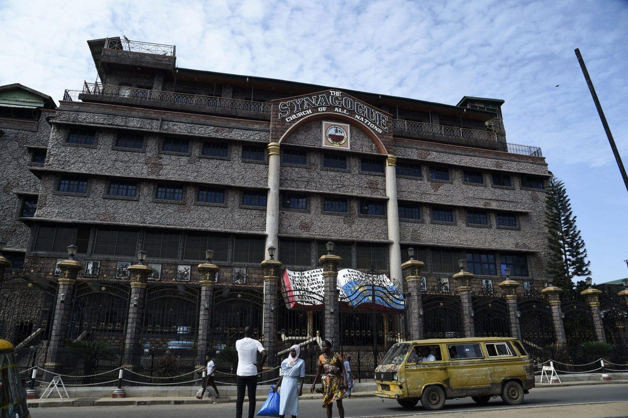 A minibus drives by as church members gather at the main gate of The Synagogue Church of All Nations (SCOA) headquarters to mourn the death of late Nigerian pastor TB Joshua, Lagos, Nigeria, June 6, 2021. (AFP Photo)