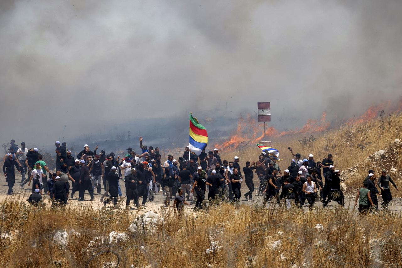 Members of Syria's Druze community walk through tear gas fumes released by Israeli forces to disperse them at Israeli-annexed Golan Heights near Majdal Shams on July 16, 2025. (AFP Photo)