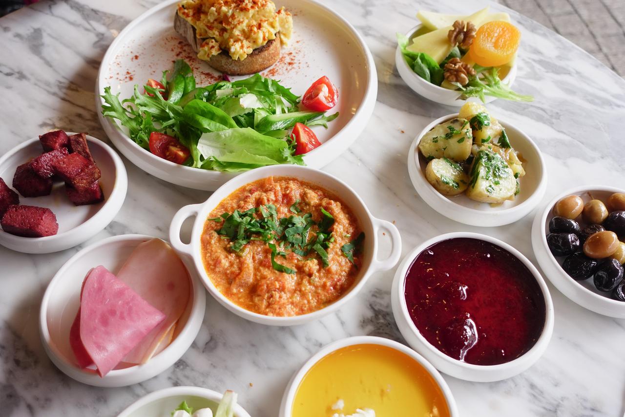A Turkish breakfast spread with menemen, olives, jam, and fresh greens served at a cafe in Istanbul, Türkiye, accessed July 18, 2025. (Adobe Stock Photo)