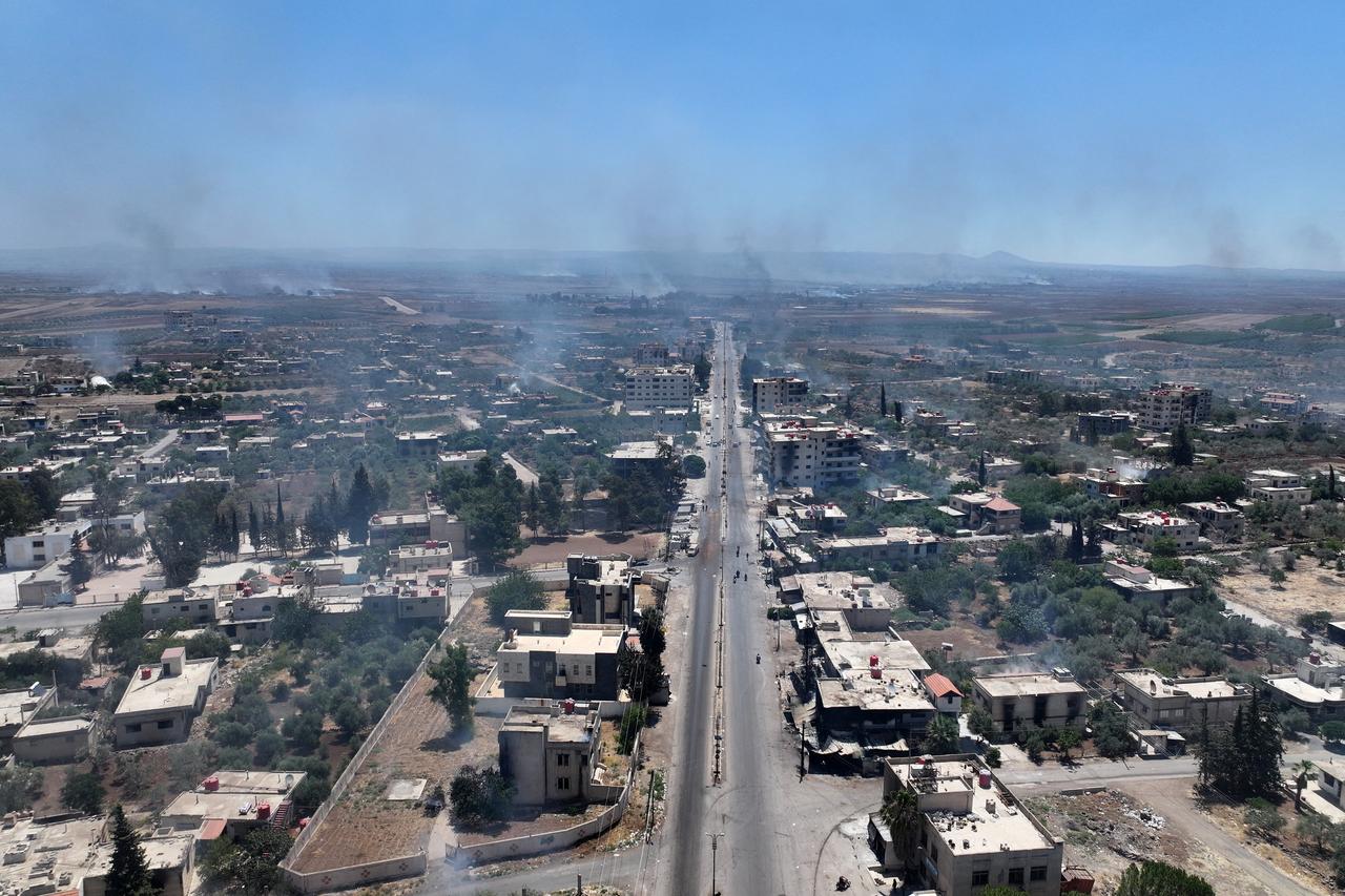 This aerial photograph shows smoke rising above buildings in al-Mazraa village in Syria's southern Sweida on July 18, 2025. (AFP Photo)