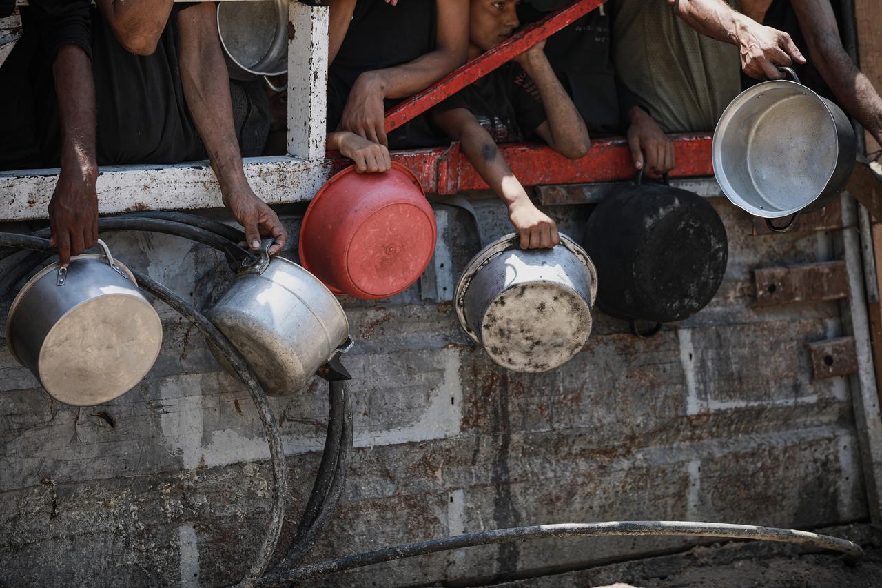 A large crowd gather during a food distribution by a charity organization on the Gaza Strip, on July 18, 2025. (AA Photo)