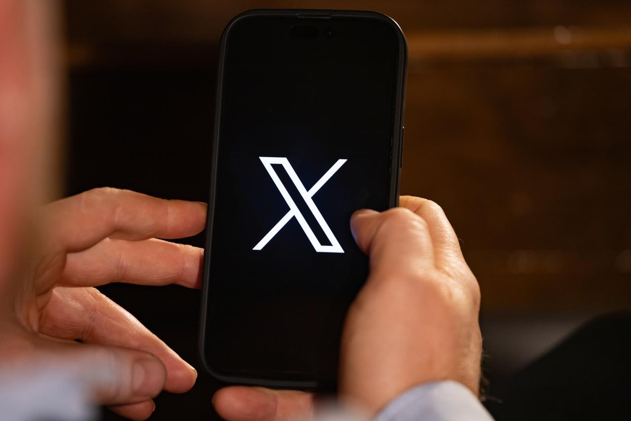 User holding a smartphone displaying the X app logo, accessed on June 2, 2025. (Adobe Stock Photo)