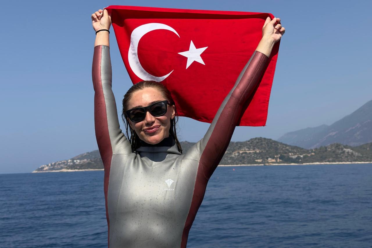 National athlete Sahika Ercumen poses with Turkish flag in hand during the Free Diving Open Water Seniors and Masters Individual Türkiye Championship held in Antalya, Türkiye, July 20, 2025. (AA Photo)
