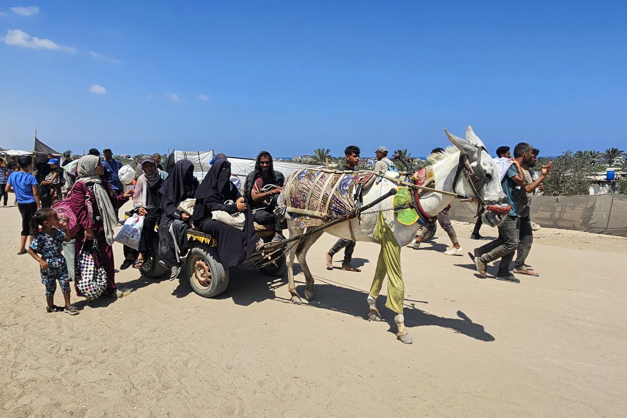 Palestinians ride in the back of animal-drawn carts in the Mawasi area of Rafah on July 20, 2025. (AA Photo)