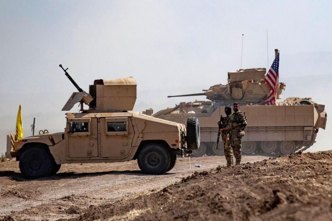 Members of the terrorist group PKK/YPG-led SDF stand near a US Bradley Fighting Vehicle (BFV) during a joint military exercise in Syrias northeastern al-Hasakah province on September 7, 2022. (AFP Photo)