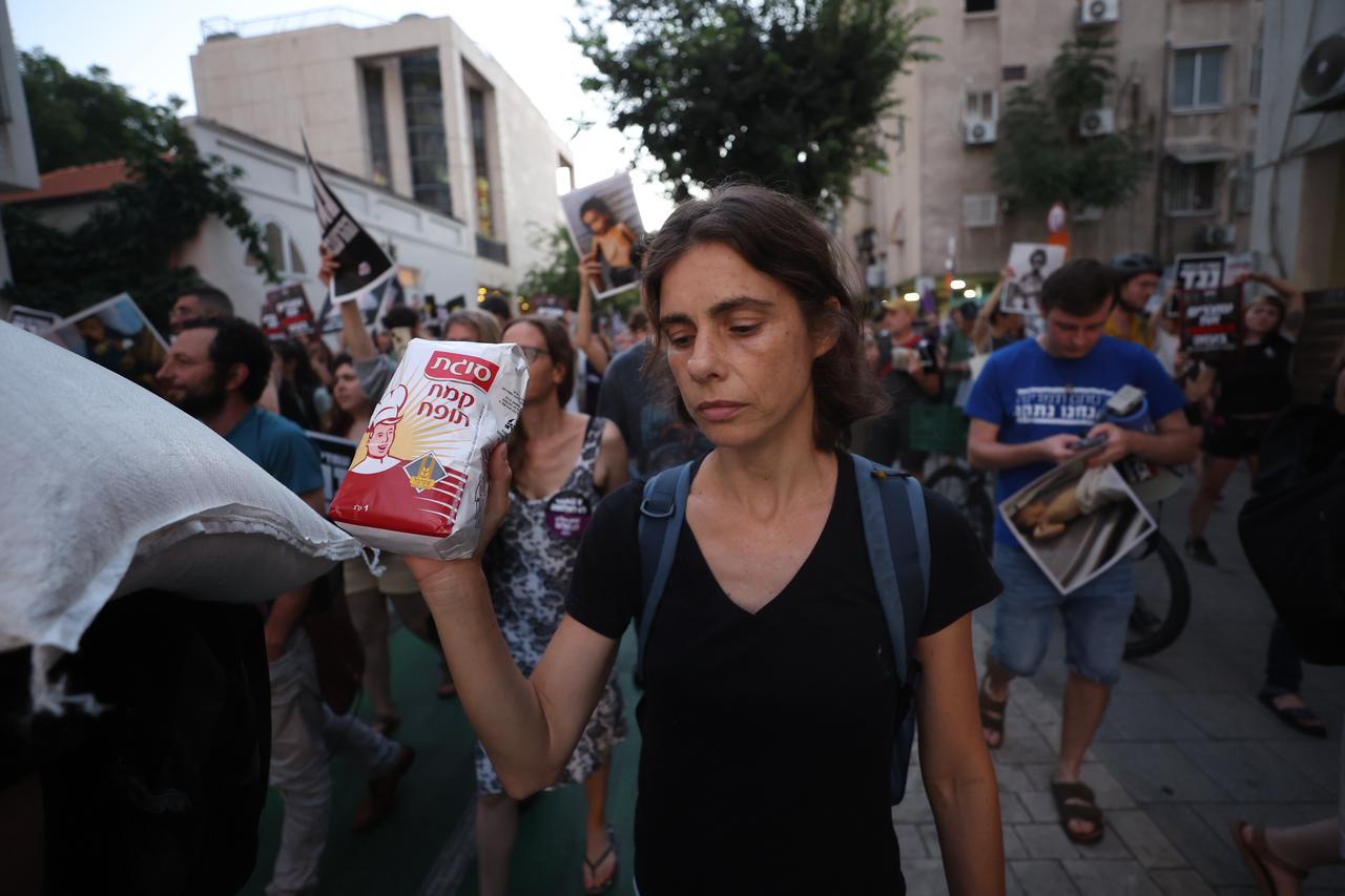 Demonstrators gather to protest and draw attention to the hunger crisis in Gaza holding sacks of flour in their hands in Tel Aviv, Israel ,July 22, 2025.(Photo via AA)