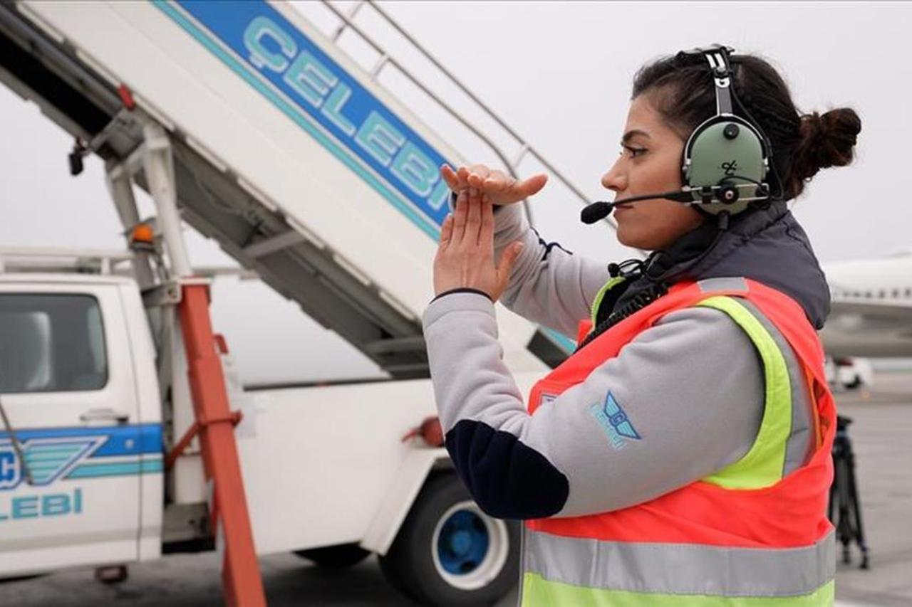 Photo shows Celebi Aviation ground services vehicle alongside company worker on an airport apron. (AA Photo)