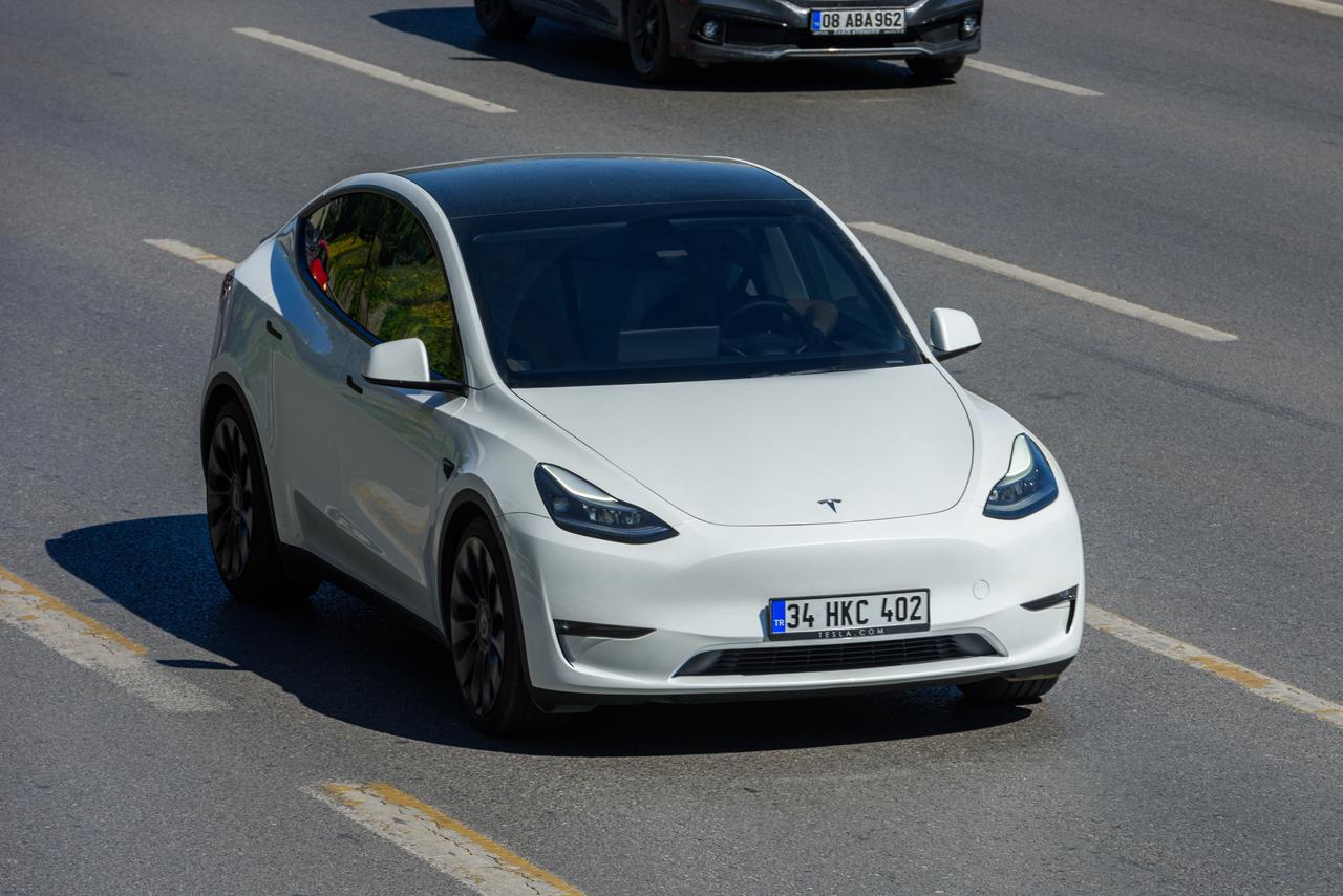 A white Tesla Model Y drives along a highway in Istanbul, Türkiye, October 29, 2024. (Adobe Stock Photo)