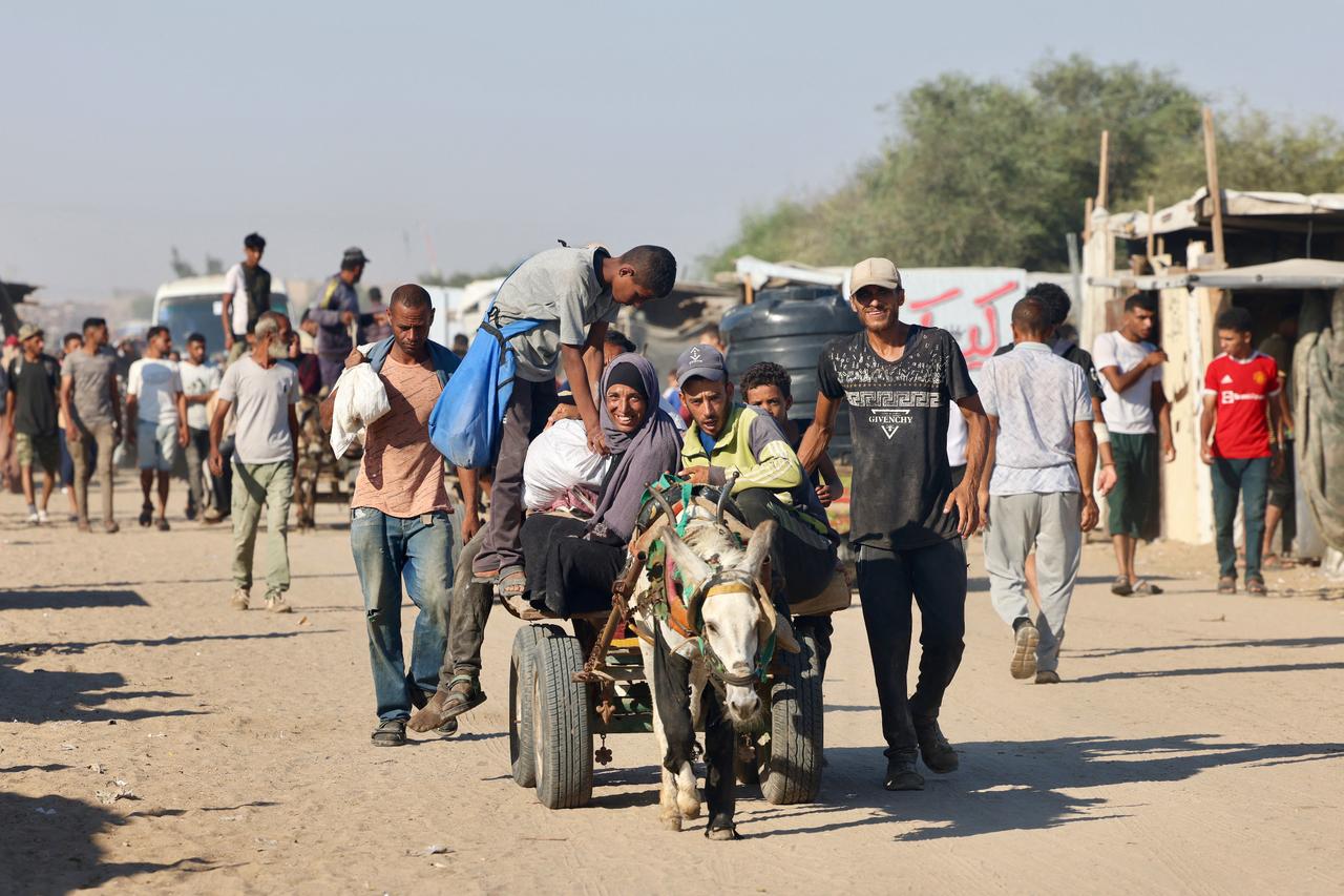 Palestinians make their way in the Mawasi area of Rafah after receiving humanitarian aid from an aid distribution point in the southern Gaza Strip on July 24, 2025. (AFP Photo)