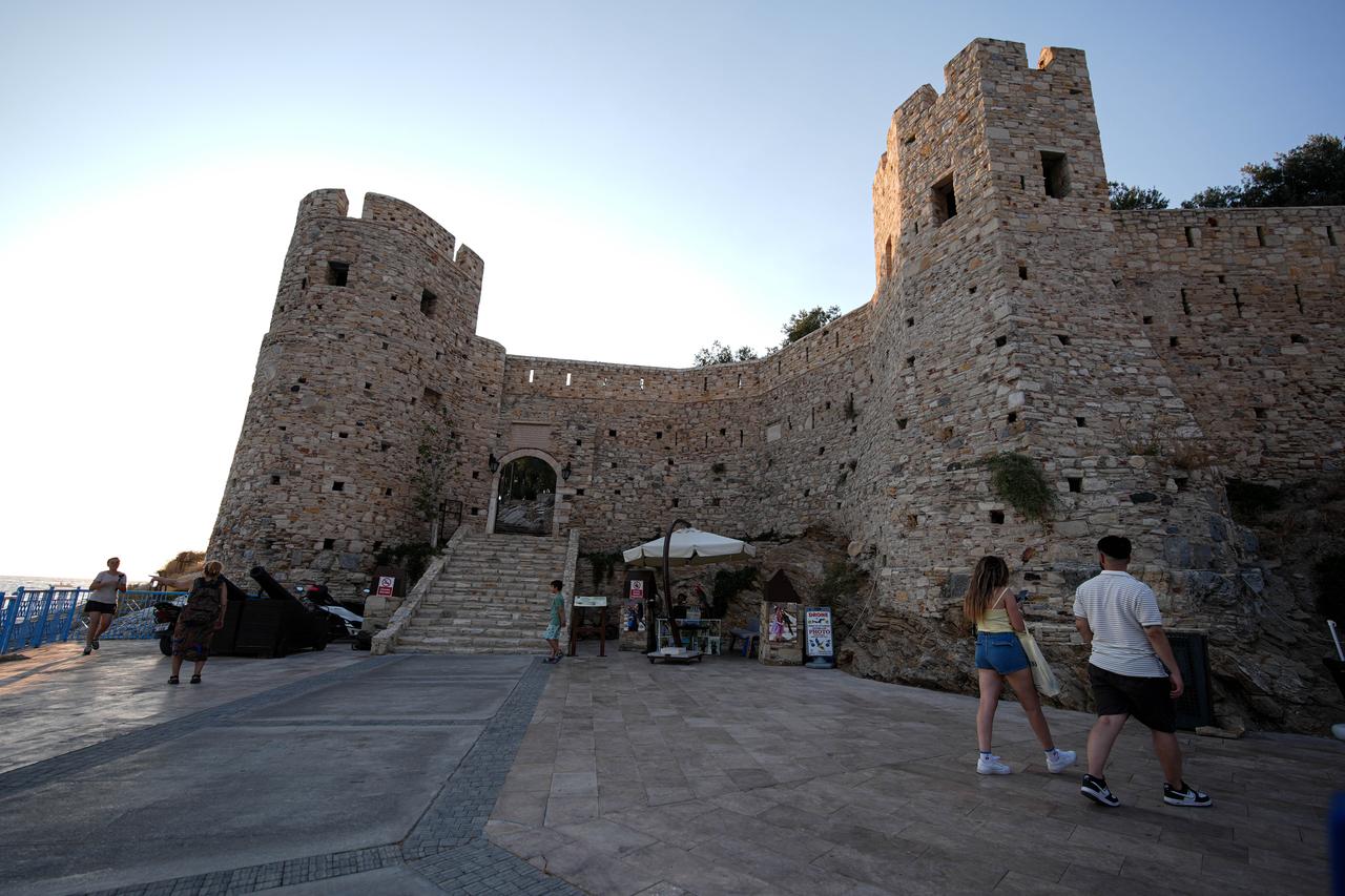 A view of historical Guvercinada (Pigeon Island) Castle, located near the harbor with the ships docking at the port in Kusadasi, Aydin, Türkiye, July 19, 2025. (AA Photo)