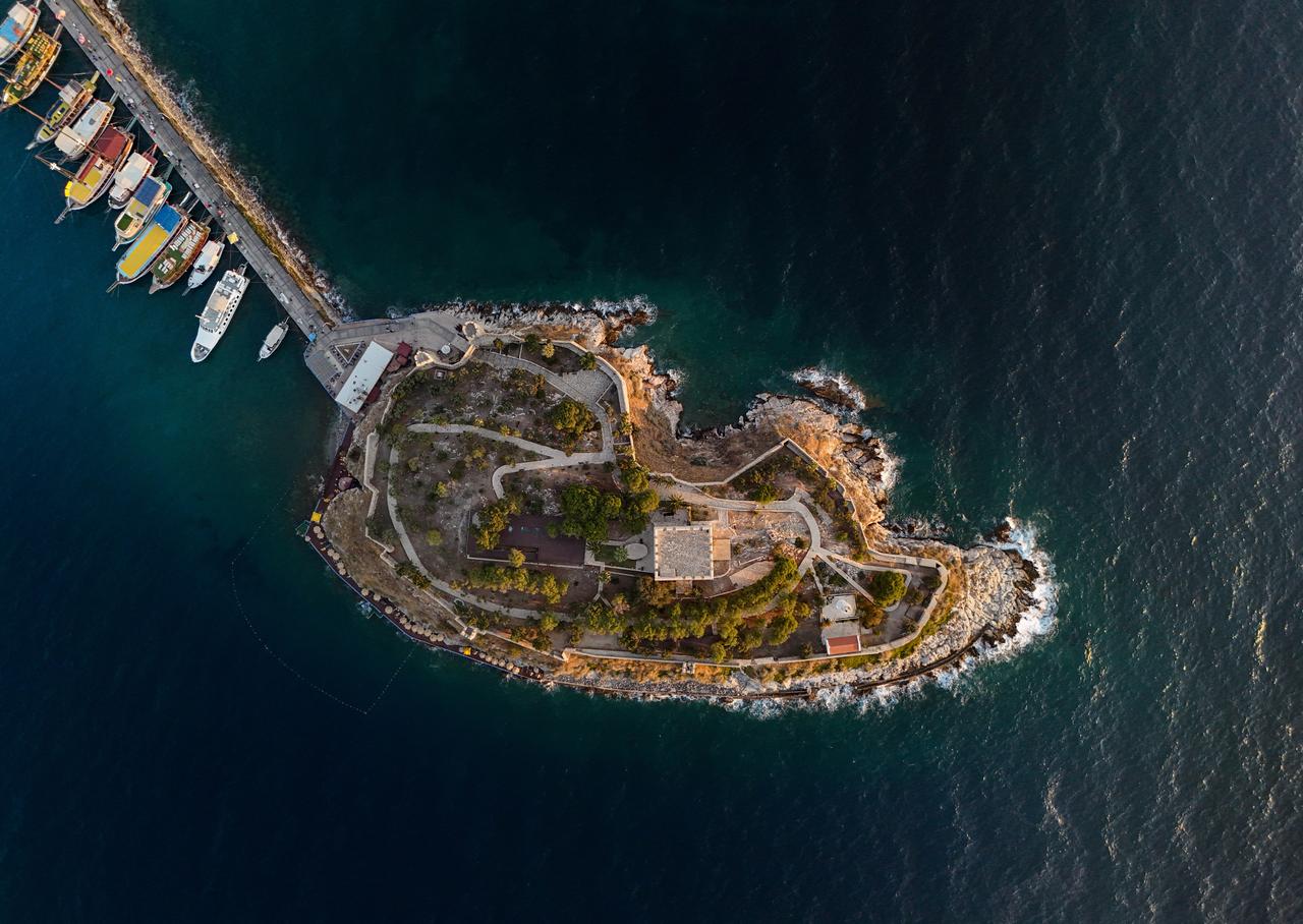 An aerial view of historical Guvercinada (Pigeon Island) Castle, located near the harbor with the ships docking at the port in Kusadasi, Aydin, Türkiye, July 19, 2025. (AA Photo)