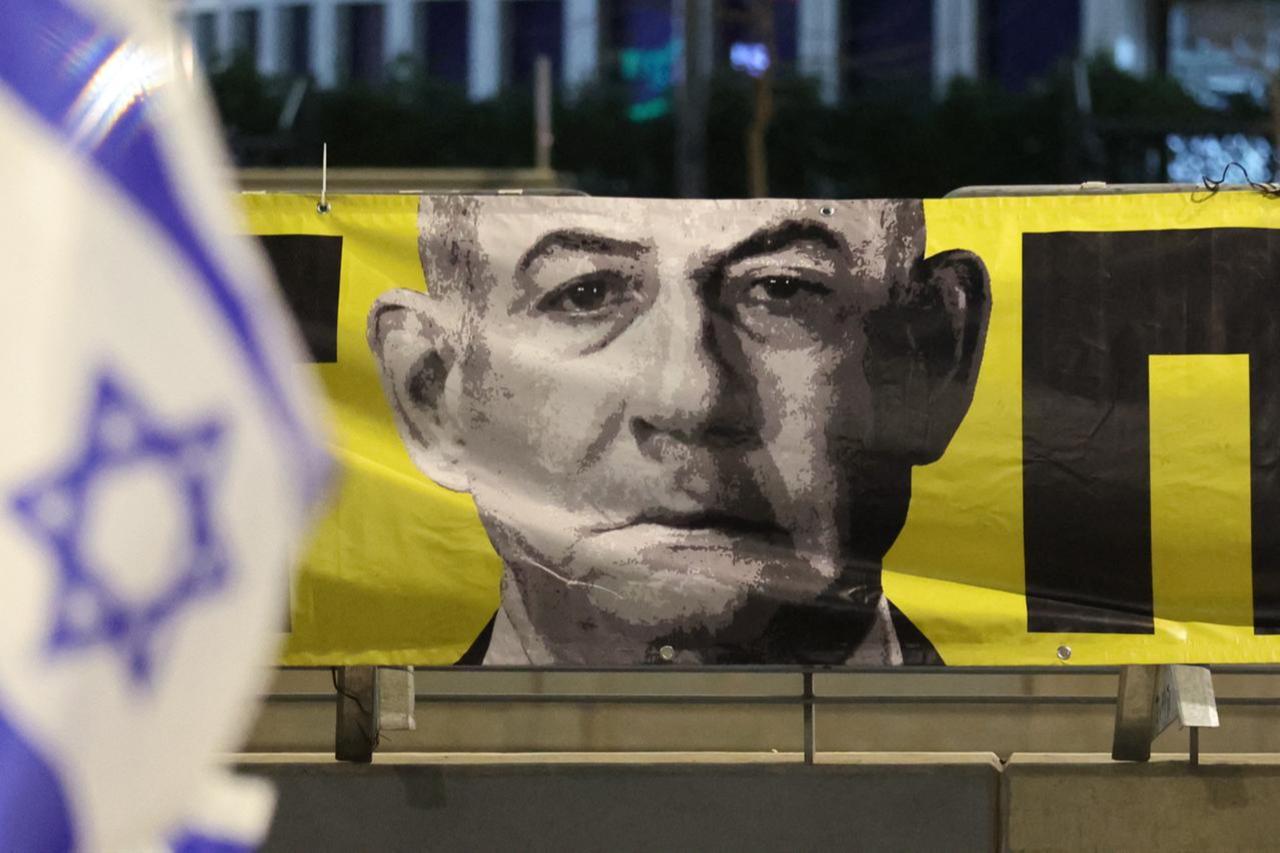 A portrait of Israels Prime Minister Netanyahu hangs on the sidewalk during a protest calling for action to secure the release of Israeli hostages, in front of the Israeli Defence Ministry in  Tel Aviv on March 29, 2025. (AFP Photo)