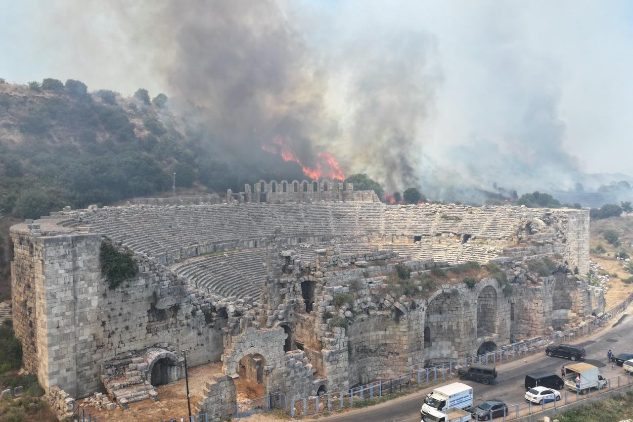 Flames are seen around the theater structure of the ancient city of Perge in Antalya, Türkiye, in a post shared on X by Isa Yildirim, Mayor of Aksu District, July 25, 2025. (Photo via X/@aksuisayildirim)