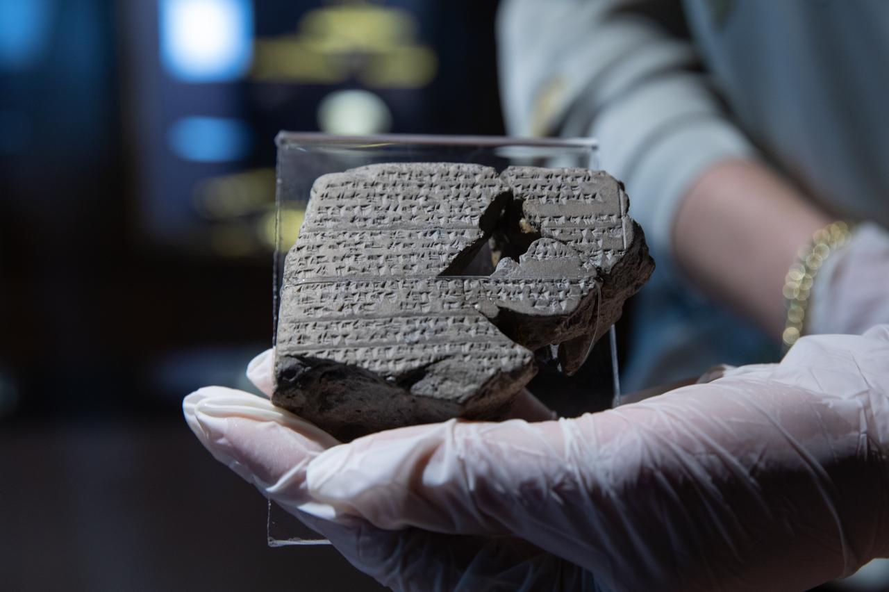 A staff member holds one of the four 3,500-year-old tablets describing several rituals on display at Izmir Archeology Museum, in Izmir, Türkiye, Dec. 11, 2021. (AA Photo)