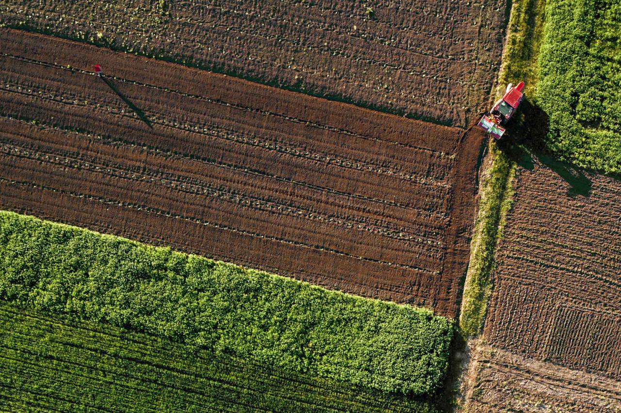 A bird’s-eye view from a drone showing a tractor tilling the soil. (Courtesy of the AgroRobottiFleet project)