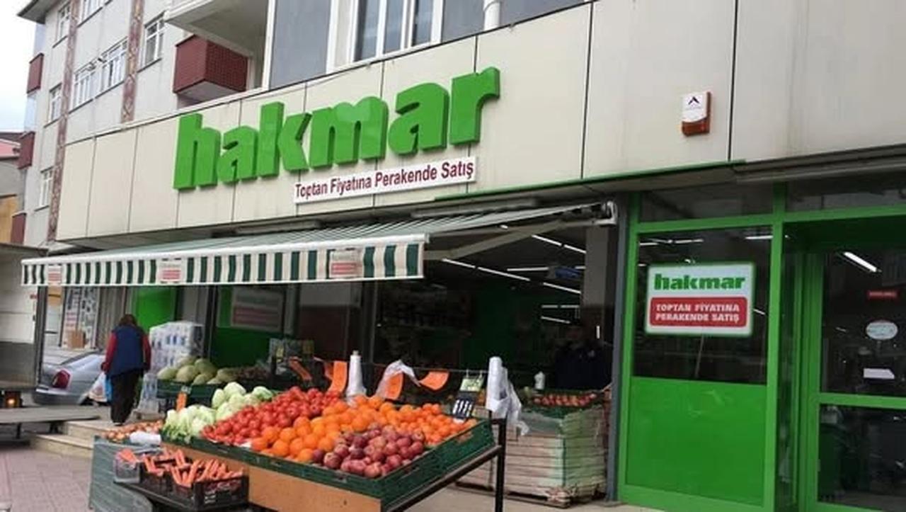 A woman walks past a Hakmar supermarket in Istanbul, Türkiye. (AA Photo)