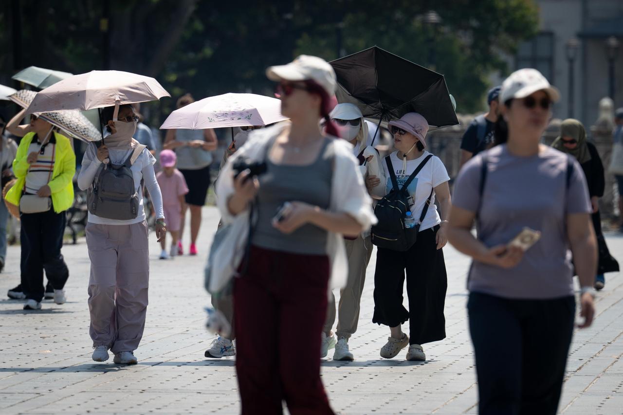 Residents and foreign tourists spend their time outdoors, walking through the streets, picnic areas, parks and tourist spots on hot days in Istanbul, Türkiye, July 27, 2025. (AA Photo)