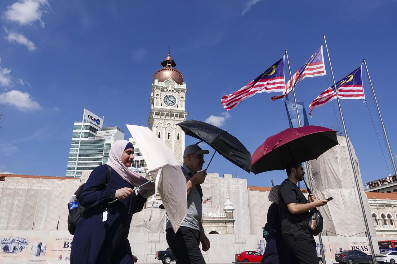 People, holding umbrellas to protect from sun, walks on a street during a hot day in Kuala Lumpur, Malaysia, July 16, 2025. (AA Photo)