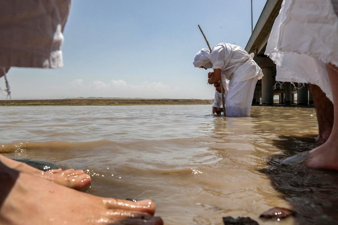 Sabian worshippers take part in a cleansing ritual known as the “Golden Baptism” along the banks of the Great Zab River in Erbil, on May 18, 2022. (Photo by AFP)