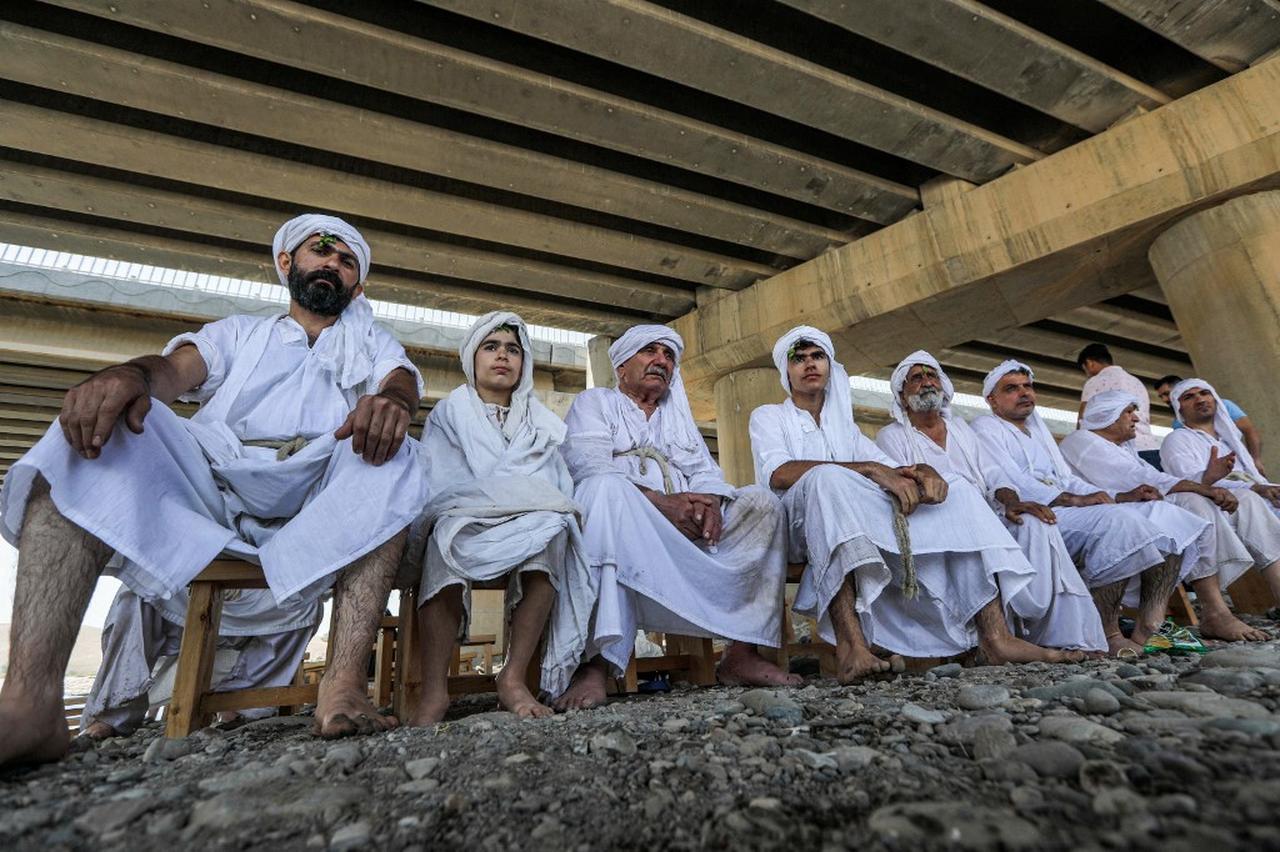 Sabian worshippers take part in a cleansing ritual known as the “Golden Baptism” along the banks of the Great Zab River in Erbil, on May 18, 2022. (Photo by AFP)