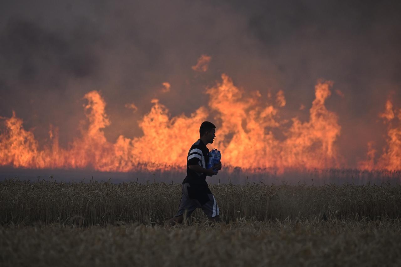 A volunteer bottles of water to extinguish a wildfire near the village of Ponor, near Sofia in Bulgaria, July 21, 2025. (AFP Photo)
