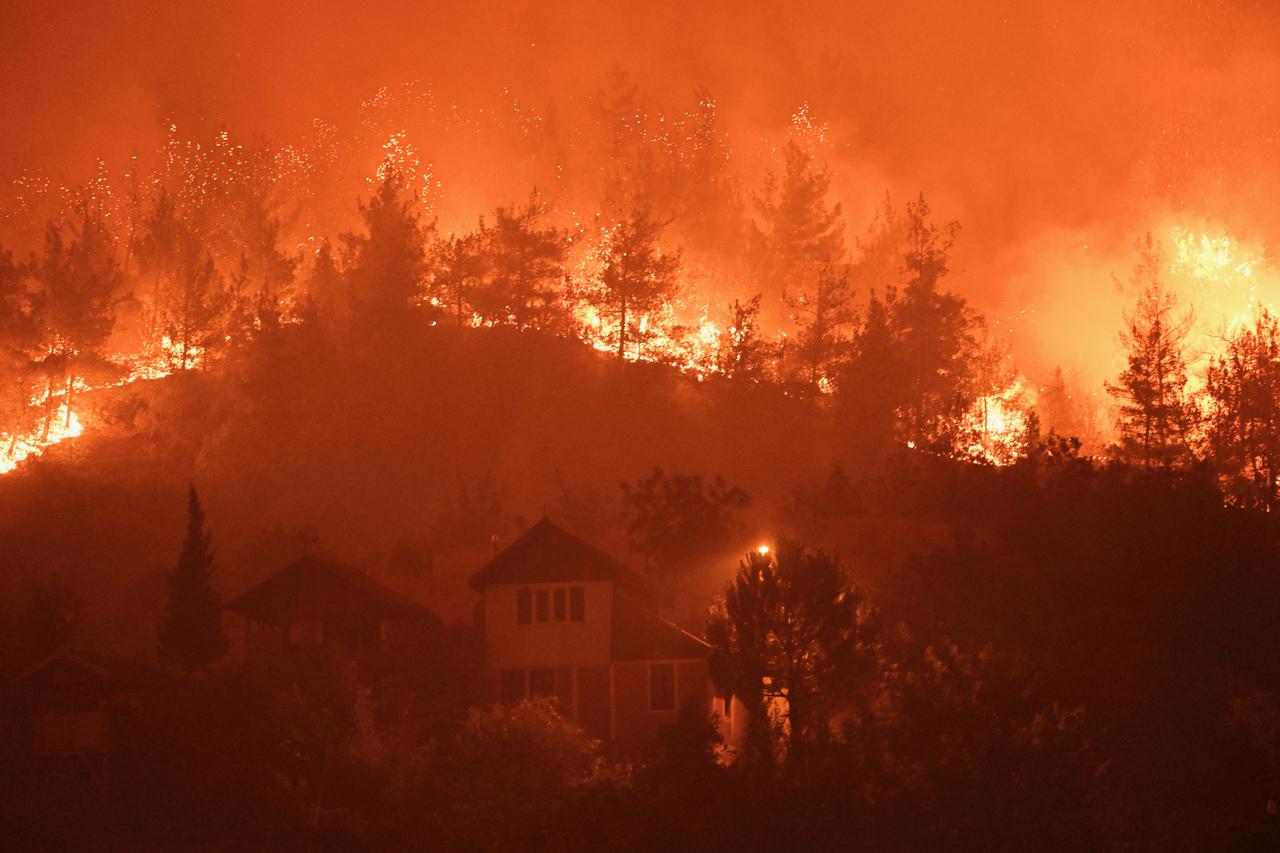 Smoke and flames rise from burning trees near residential areas while teams continue their efforts to extinguish the fire that broke out in the forest areas at night on July 26, 2025 in Safranbolu district of Karabuk, Türkiye. (AA Photo)