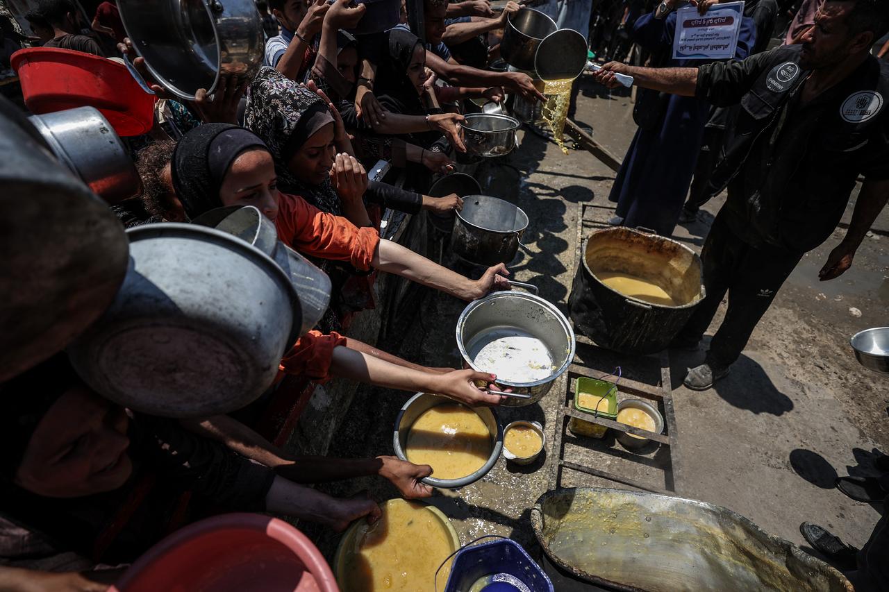 A charity distributes meals to Palestinians facing food shortages amid ongoing Israeli attacks and severe restrictions in Gaza City, Gaza on July 28, 2025. (AA Photo)