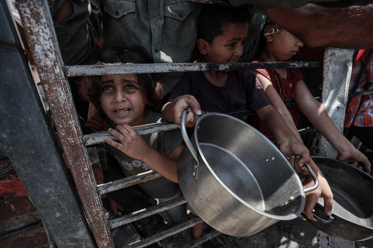 Palestinians, including children, who are struggling to access food due to Israels blockade and ongoing attacks on the Gaza Strip, wait in line to receive hot meals distributed by the charity organization in Gaza City, Gaza, July 30, 2025. (AA Photo)