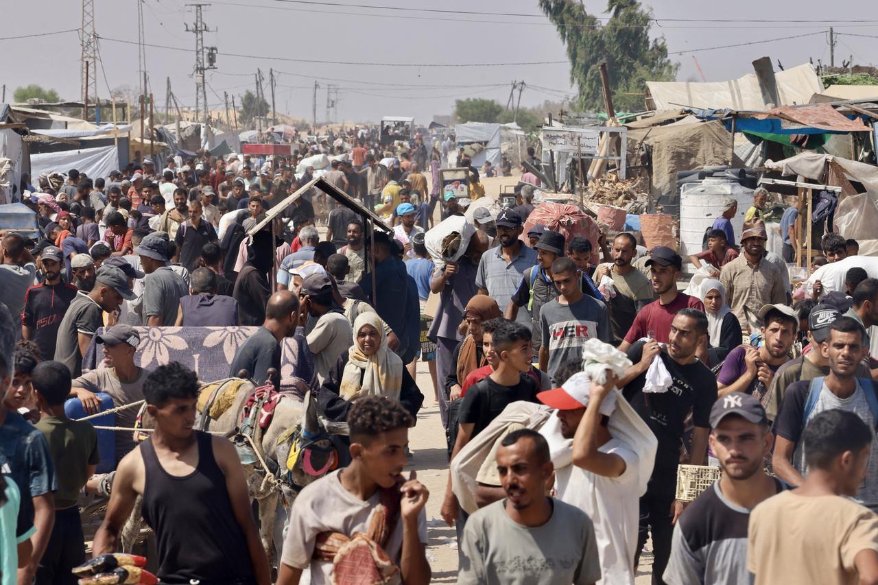 Palestinians carry humanitarian aid they received at the Rafah corridor as they walk in the Mawasi area of Rafah in the southern Gaza Strip on July 30, 2025. (AFP Photo)