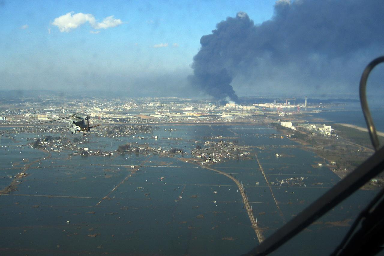 An SH-60F helicopter assigned to the Chargers of Helicopter Antisubmarine Squadron (HS) 14 from Naval Air Facility Atsugi flies over the port of Sendai to deliver more than 1,500 pounds of food to survivors of an 9.0 magnitude earthquake and a tsunami (2011 Tōhoku earthquake and tsunami). (Photo via Wikimedia)