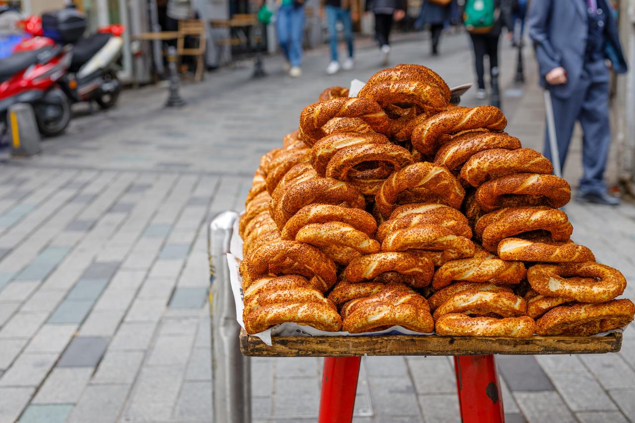 A street vendors stand stacked high with simit, a popular Turkish sesame-covered bread ring, in Istanbul, Türkiye. (Adobe Stock Photo)